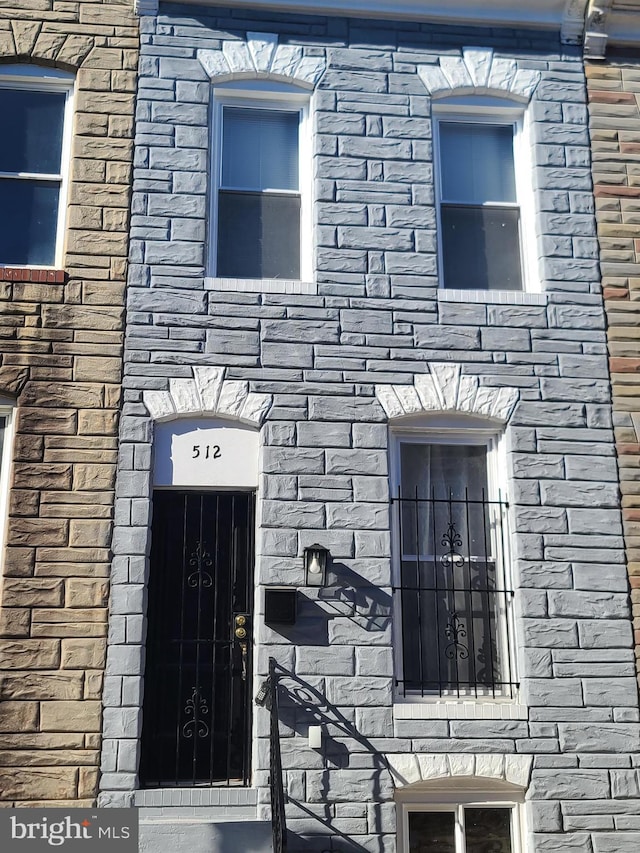 doorway to property with stone siding and brick siding