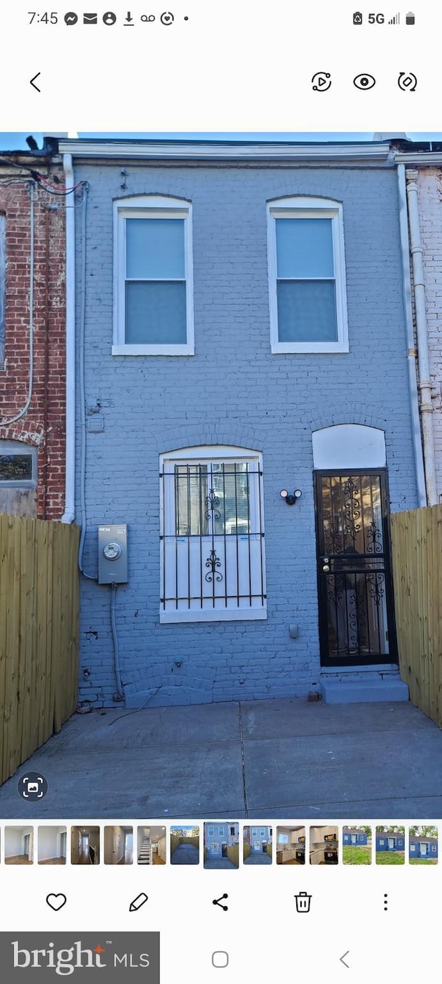 view of front of home with brick siding and fence