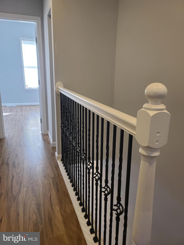 corridor with baseboards and wood finished floors