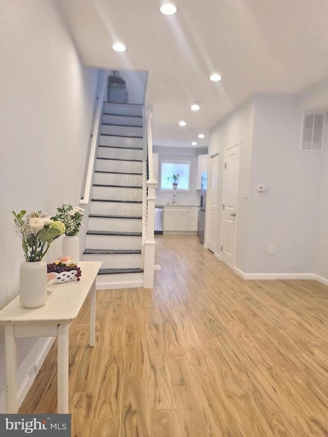 interior space featuring light wood-type flooring, stairs, visible vents, and recessed lighting