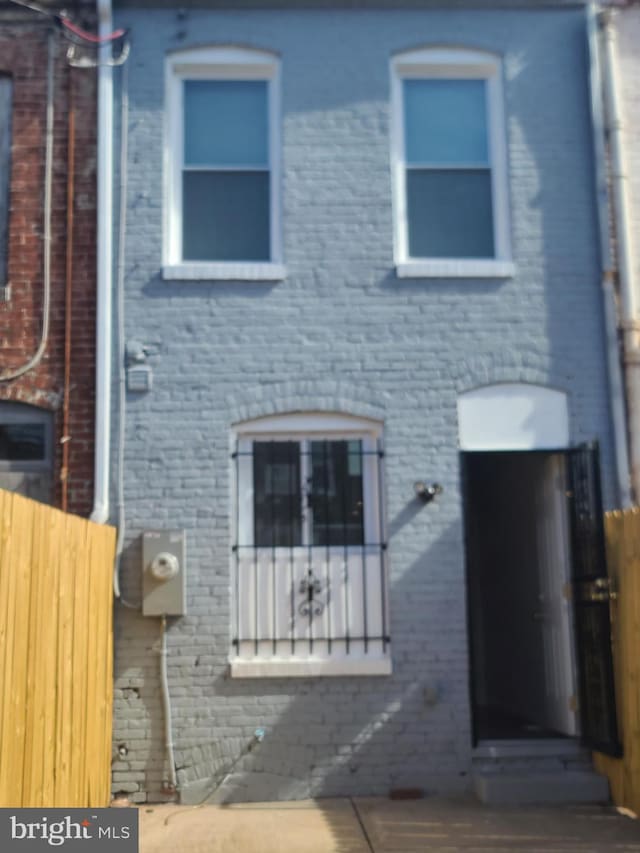 view of front of property with fence and brick siding