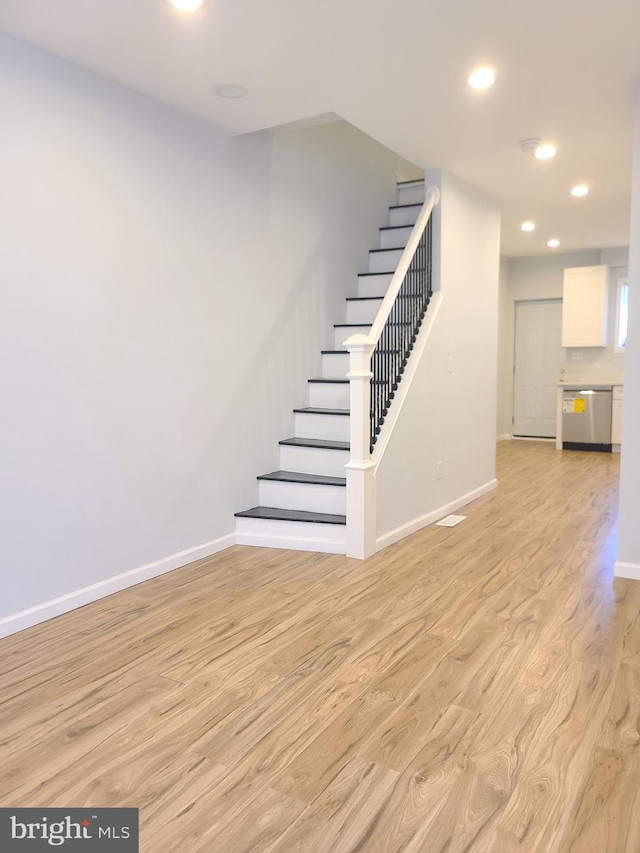 stairway featuring recessed lighting, wood finished floors, and baseboards