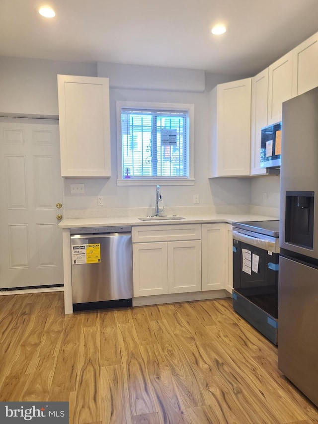 kitchen featuring white cabinetry, appliances with stainless steel finishes, and a sink