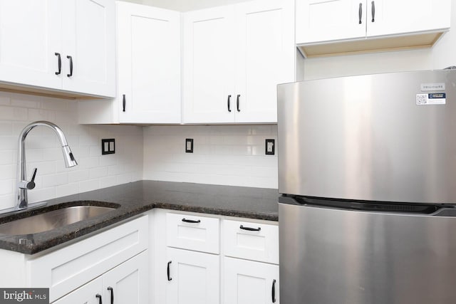 kitchen with sink, stainless steel fridge, and white cabinets