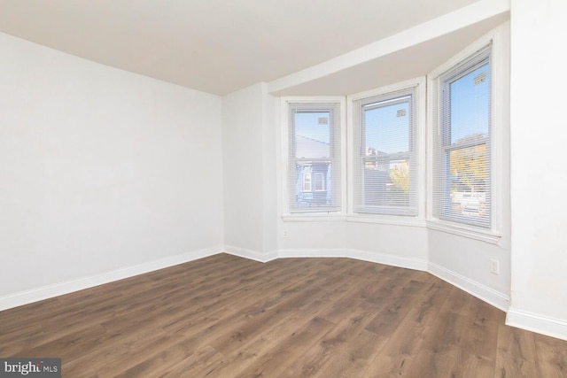 spare room featuring dark wood-type flooring