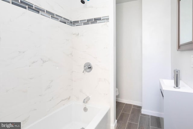 full bathroom featuring toilet, tiled shower / bath, and vanity