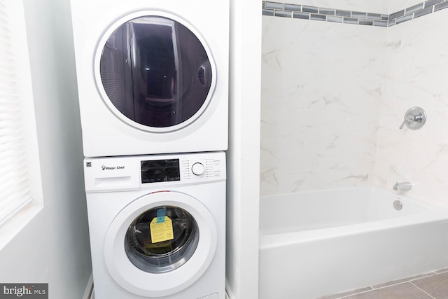 clothes washing area featuring stacked washer / dryer and tile patterned flooring