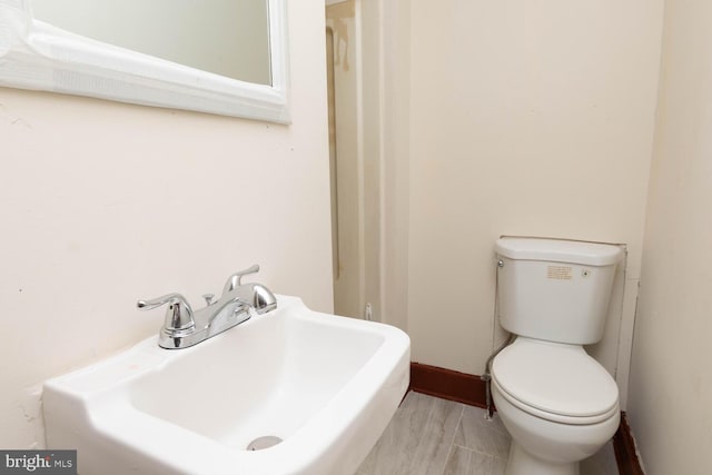 bathroom featuring sink, wood-type flooring, and toilet