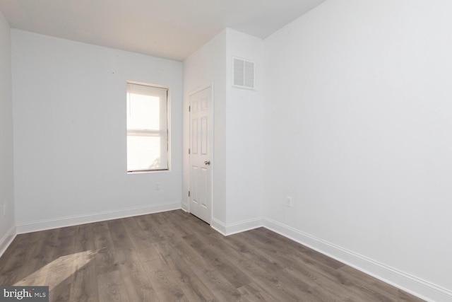 unfurnished room with dark hardwood / wood-style flooring