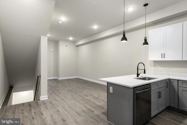 kitchen featuring kitchen peninsula, white cabinets, stainless steel dishwasher, pendant lighting, and sink