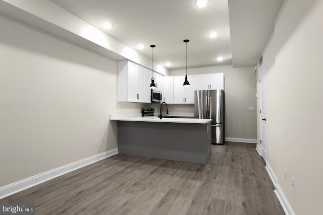 kitchen featuring appliances with stainless steel finishes, kitchen peninsula, light hardwood / wood-style flooring, and white cabinets