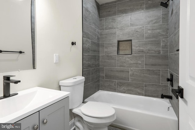 full bathroom featuring toilet, tiled shower / bath combo, and vanity