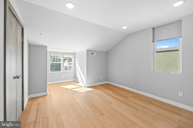 additional living space with lofted ceiling and light wood-type flooring