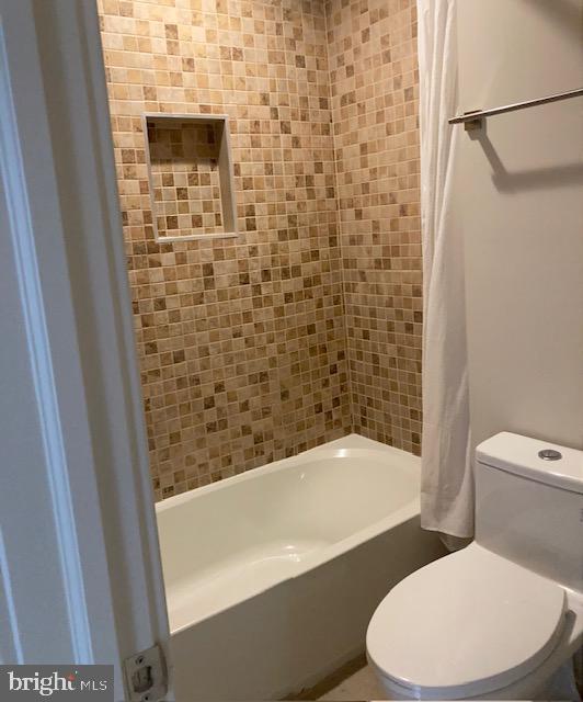 bathroom with toilet and shower / tub combo