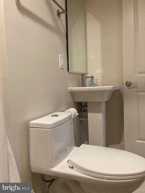 bathroom featuring toilet and a shower with curtain