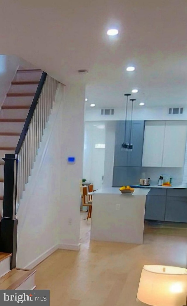 kitchen featuring white cabinetry, decorative light fixtures, and gray cabinets