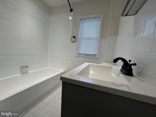 bathroom with vanity, tile walls, and shower / washtub combination