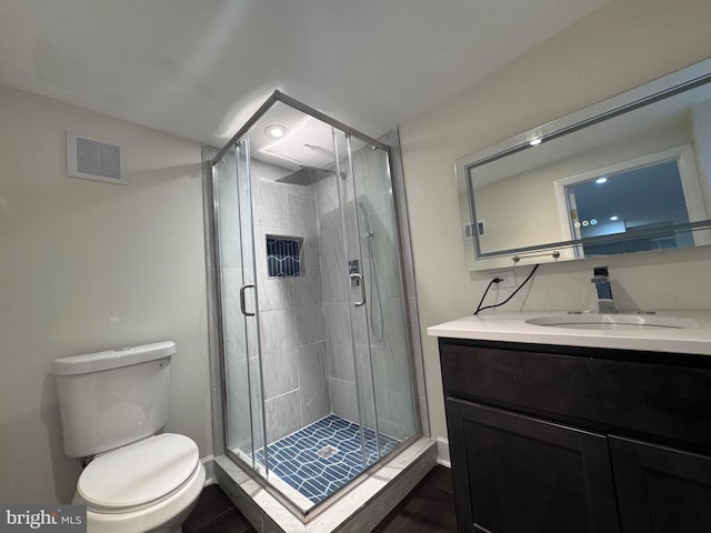 bathroom with vanity, toilet, and an enclosed shower