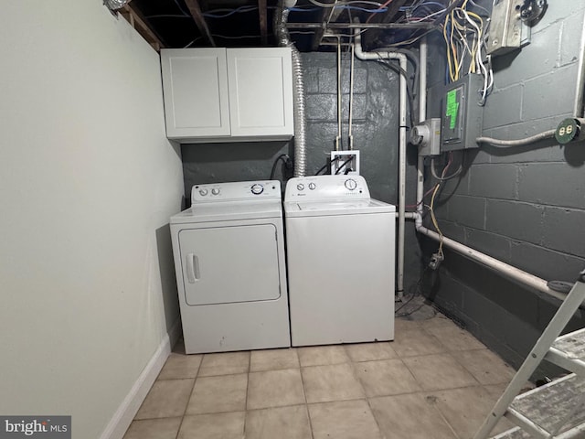 laundry room with separate washer and dryer, electric panel, light tile patterned floors, and cabinets