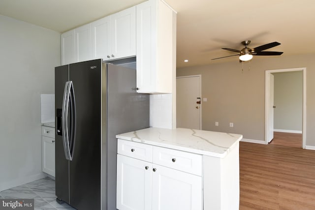 kitchen featuring light stone counters, white cabinetry, stainless steel fridge with ice dispenser, and ceiling fan