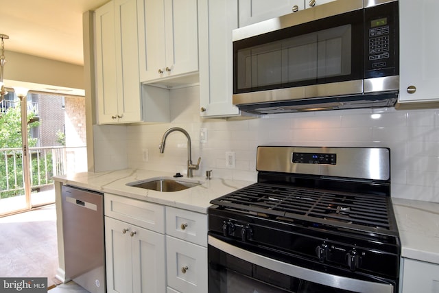 kitchen with white cabinetry, appliances with stainless steel finishes, sink, and decorative backsplash