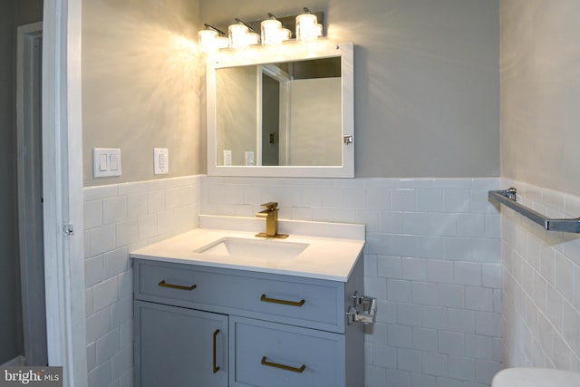 bathroom featuring vanity and tile walls