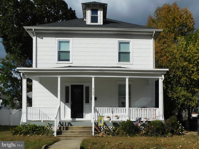 view of front facade featuring roof with shingles and a porch