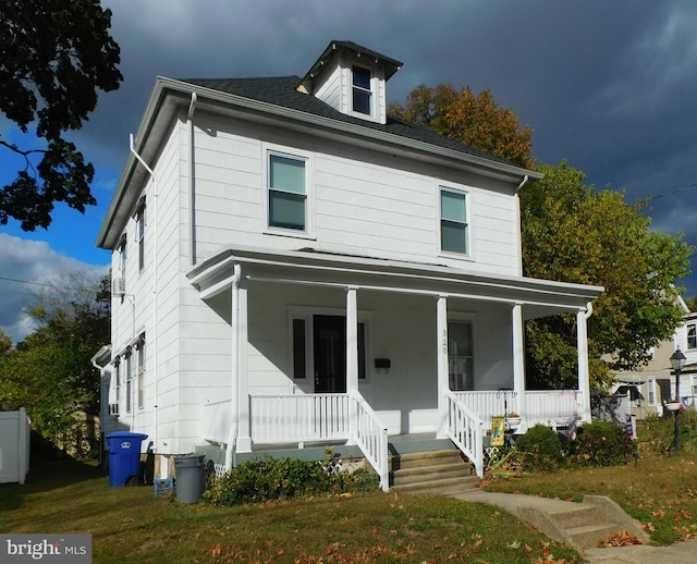 view of front of property with a porch and a front lawn