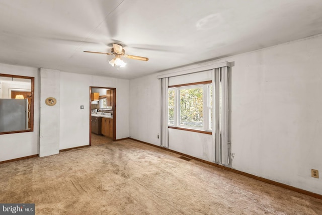 unfurnished room with ceiling fan and light colored carpet