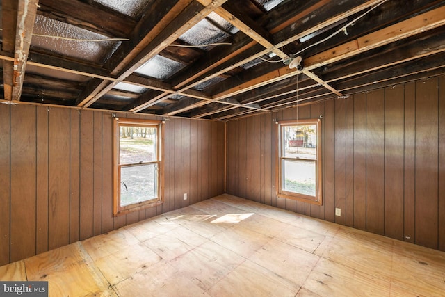 unfurnished room featuring wood walls and a wealth of natural light