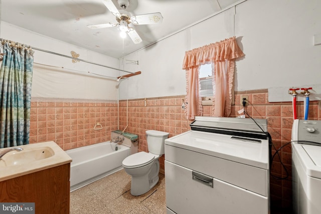 full bathroom featuring vanity, toilet, tile walls, and washer and clothes dryer