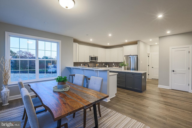 kitchen with white cabinetry, kitchen peninsula, stainless steel appliances, and dark hardwood / wood-style floors