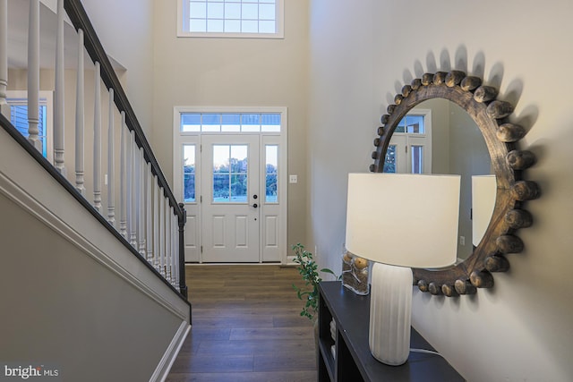 entryway featuring a towering ceiling and dark hardwood / wood-style flooring