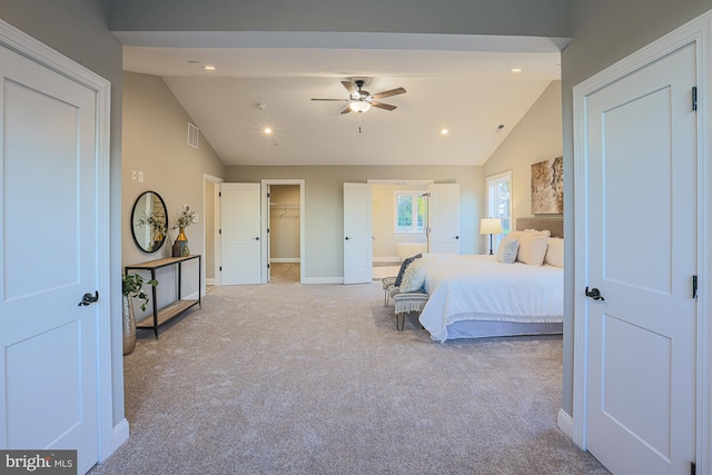 carpeted bedroom with lofted ceiling, a closet, a walk in closet, and ceiling fan