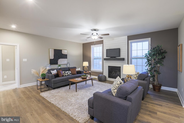 living room with hardwood / wood-style floors, a fireplace, and ceiling fan