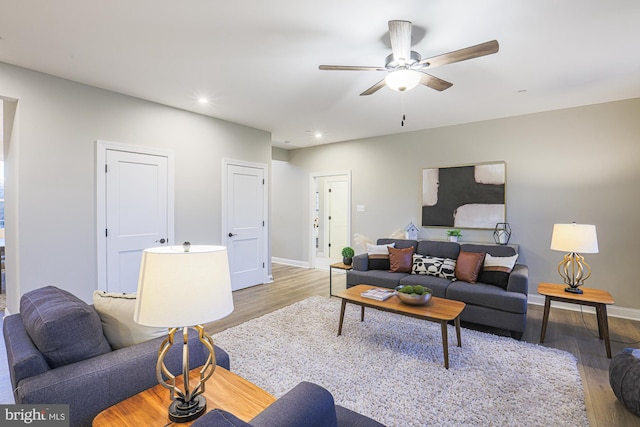 living room with light wood-type flooring and ceiling fan