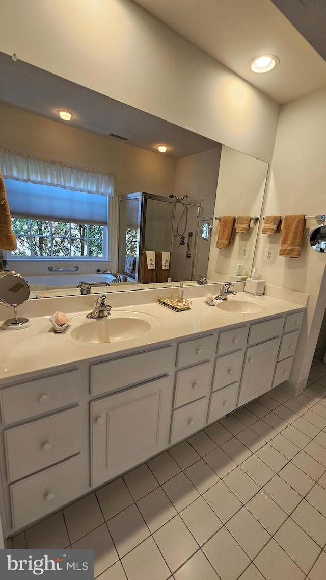 bathroom featuring vanity, a shower with shower door, and tile patterned floors