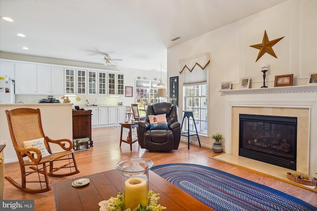 29748 Lyons Dr, Easton, MD 21601 - living room featuring recessed lighting, light wood finished floors, a glass covered fireplace, ceiling fan, and visible vents