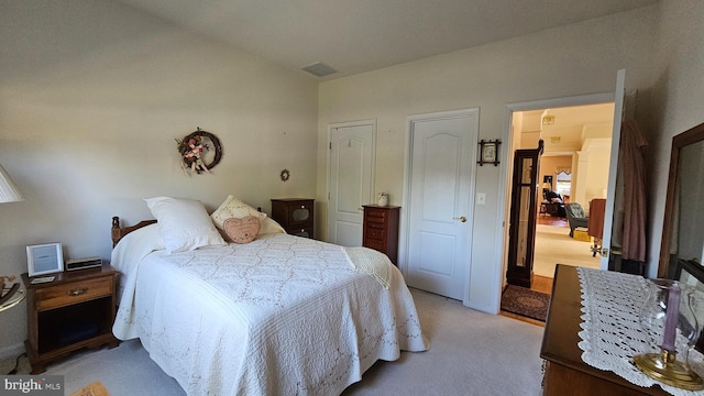 bedroom featuring lofted ceiling and light colored carpet