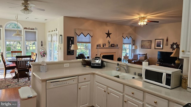 kitchen featuring white appliances, wood-type flooring, sink, ceiling fan, and white cabinets