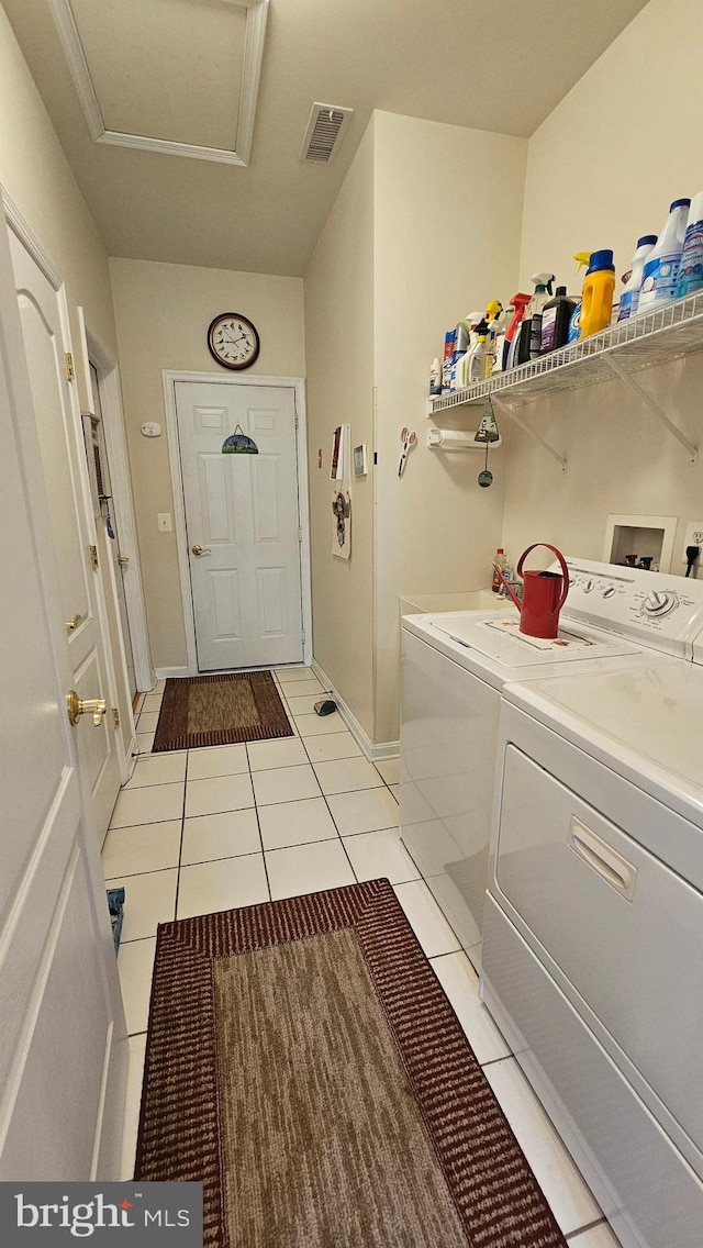 clothes washing area with light tile patterned flooring and separate washer and dryer