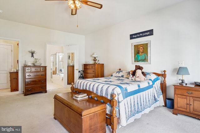 carpeted bedroom with ensuite bath and ceiling fan