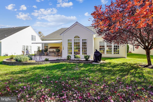 back of house with a patio and a lawn