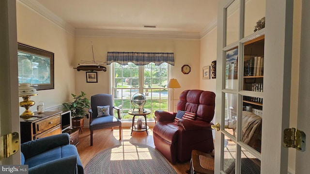 living area featuring crown molding and hardwood / wood-style floors