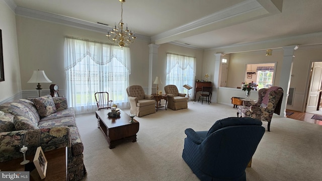 living room with ornamental molding, a notable chandelier, and ornate columns