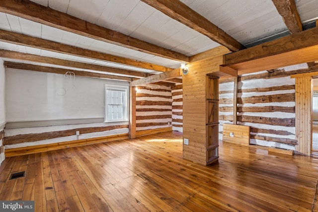 empty room with wood ceiling, wood-type flooring, and beamed ceiling