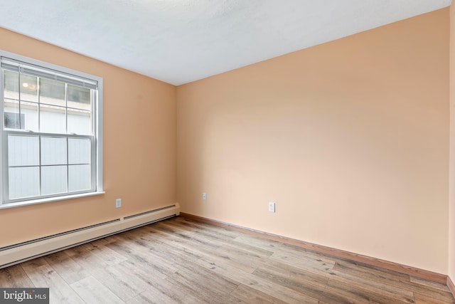 empty room with a baseboard radiator and light wood-type flooring