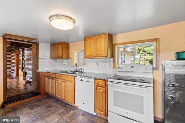 kitchen featuring tasteful backsplash, sink, light stone counters, and white appliances