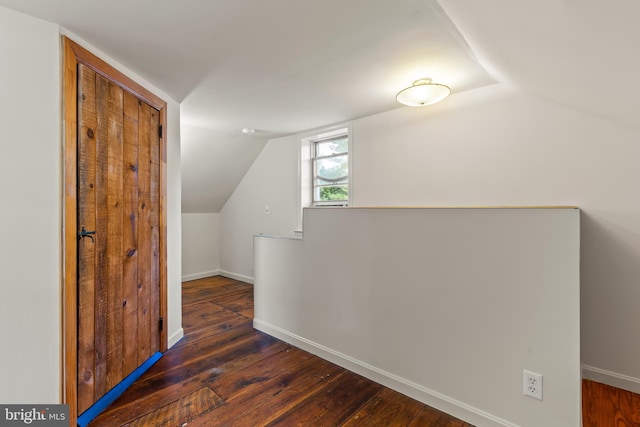 additional living space featuring lofted ceiling and dark hardwood / wood-style flooring