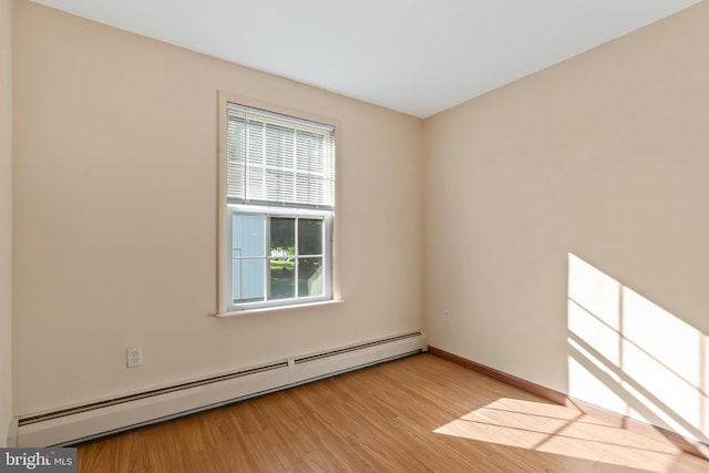 empty room with a baseboard heating unit and light wood-type flooring